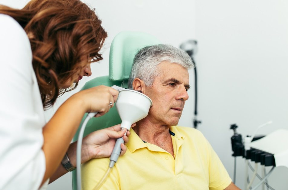 Audiologist performing earwax removal