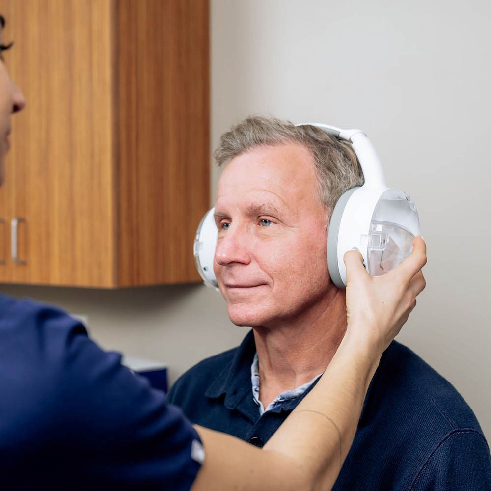 Audiologist performing earwax removal